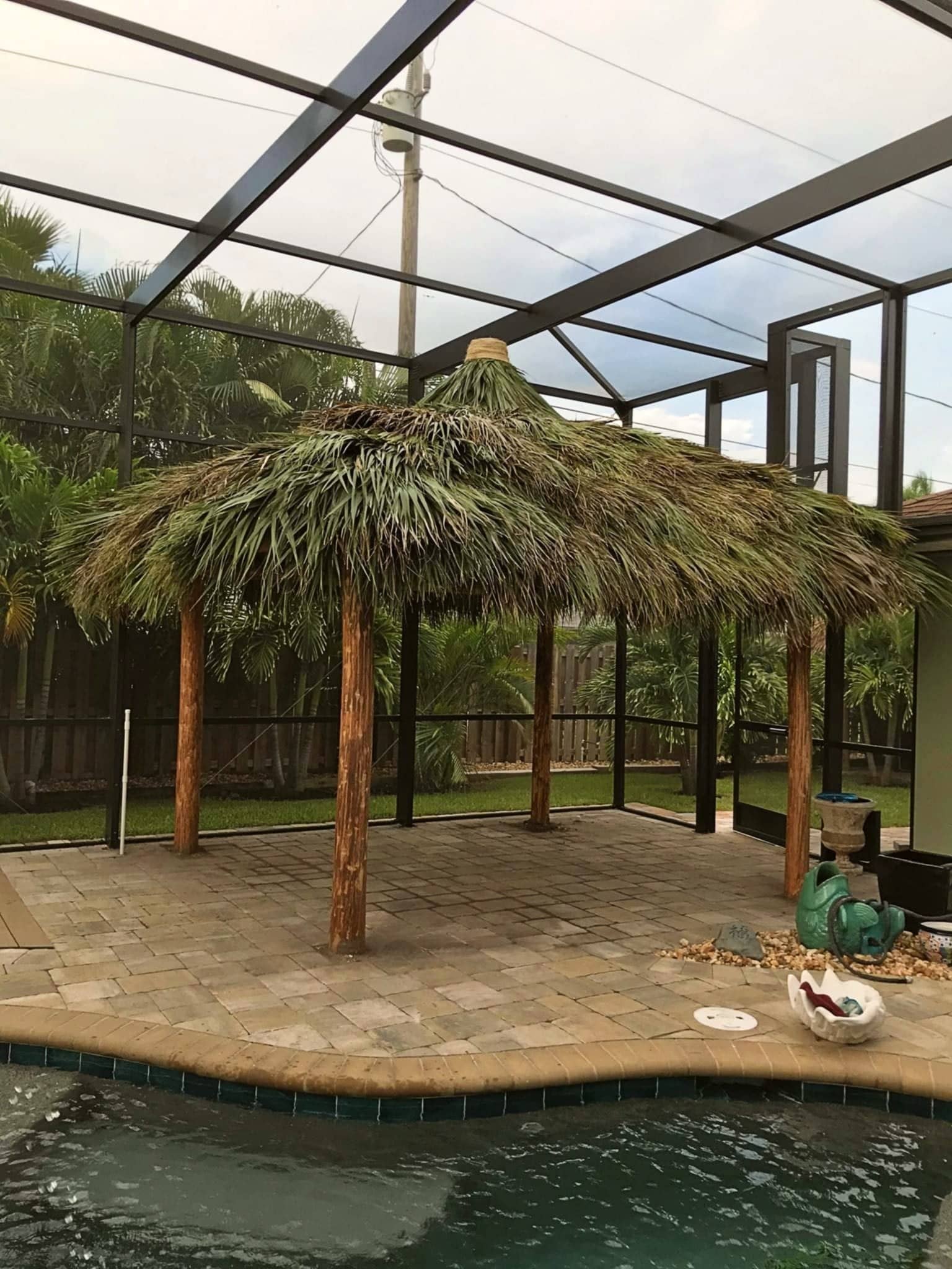 Tiki hut built inside a pool cage